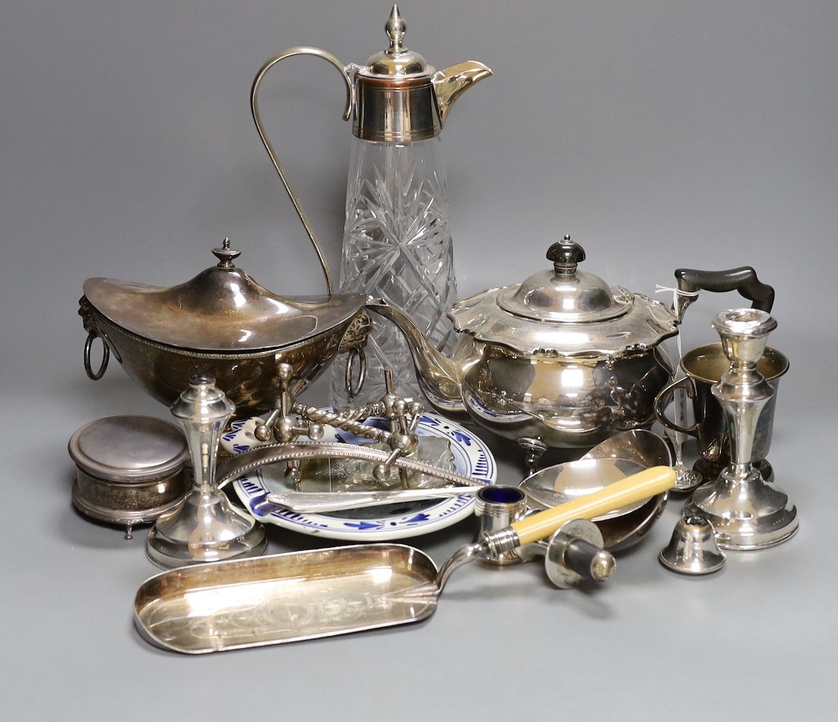 Assorted plated ware including a claret jug, teapot, sauce tureen, a pair of silver mounted dwarf candlesticks(a.f.) etc.